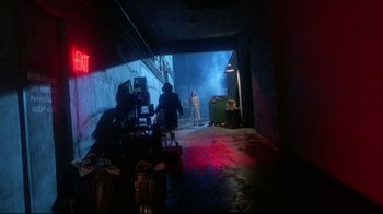 Movie still from “Masters of the Universe” (1987), directed by Gary Goddard – A person standing in a room with a fire hydrant in front of him; Wide shot, Over the shoulder angle