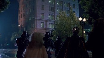 Movie still from “Masters of the Universe” (1987), directed by Gary Goddard – A group of people standing in front of a tall building at night; Wide shot, Low angle