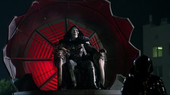 Movie still from “Masters of the Universe” (1987), directed by Gary Goddard – A statue of a man sitting in a chair; Wide shot, Low angle