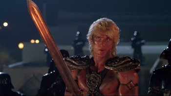 Movie still from “Masters of the Universe” (1987), directed by Gary Goddard – A person holding a sword in a room; Medium shot, Low angle