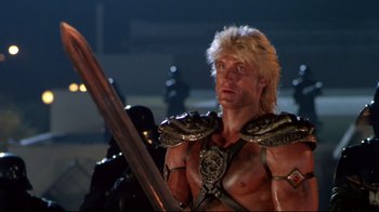 Movie still from “Masters of the Universe” (1987), directed by Gary Goddard – A man with a sword and helmet on; Medium shot, Low angle