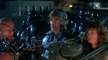 Movie still from “Masters of the Universe” (1987), directed by Gary Goddard – A group of people in a dark room with helmets on; Medium shot, Low angle