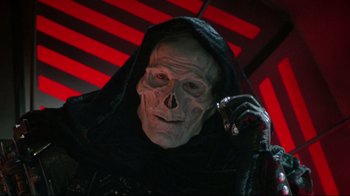 Movie still from “Masters of the Universe” (1987), directed by Gary Goddard – A man with a skull mask on talking on a cell phone; Close Up shot, Low angle