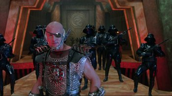Movie still from “Masters of the Universe” (1987), directed by Gary Goddard – A group of men in costume are standing in a room; Medium shot, Low angle