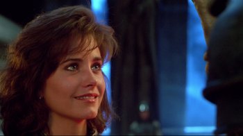 Movie still from “Masters of the Universe” (1987), directed by Gary Goddard – A woman smiling for the camera; Close Up shot, Over the shoulder angle