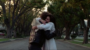 Movie still from “Masters of the Universe” (1987), directed by Gary Goddard – A man and a woman hugging each other on the side of the road; Medium shot, Low angle