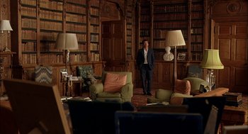 Movie still from “Match Point” (2005), directed by Woody Allen – A man standing in a room full of bookshelves; Wide shot, Over the shoulder angle