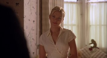 Movie still from “Match Point” (2005), directed by Woody Allen – A woman in a white shirt is posing for a picture; Medium shot, Over the shoulder angle