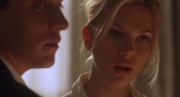 Movie still from “Match Point” (2005), directed by Woody Allen – A young woman looking at the camera while a man looks at her face; Close Up shot, Low angle