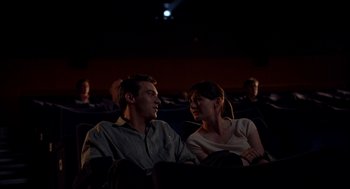 Movie still from “Match Point” (2005), directed by Woody Allen – A man and a woman sitting next to each other in a movie theater; Medium shot, High angle