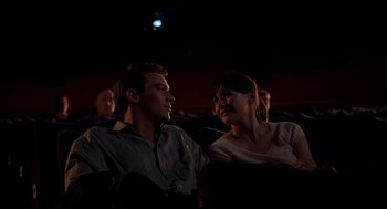 Movie still from “Match Point” (2005), directed by Woody Allen – A man and a woman sitting next to each other in a movie theater; Medium shot, Low angle