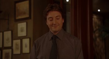 Movie still from “Match Point” (2005), directed by Woody Allen – A man in a dress shirt and a tie is smiling; Close Up shot, Over the shoulder angle