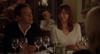Movie still from “Match Point” (2005), directed by Woody Allen – A man and a woman sitting at a table with wine glasses on it; Medium shot, Over the shoulder angle