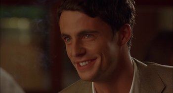 Movie still from “Match Point” (2005), directed by Woody Allen – A person with a smile on his face; Close Up shot, Over the shoulder angle