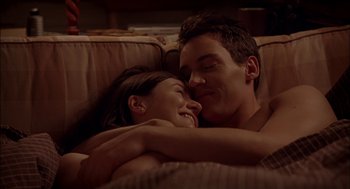 Movie still from “Match Point” (2005), directed by Woody Allen – A man and a woman laying on a couch together; Medium shot, Overhead angle