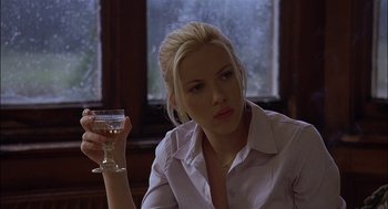 Movie still from “Match Point” (2005), directed by Woody Allen – A woman holding a wine glass in her right hand; Close Up shot, Over the shoulder angle