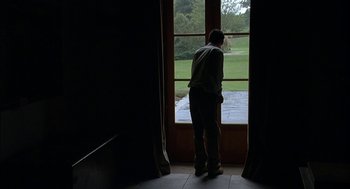 Movie still from “Match Point” (2005), directed by Woody Allen – A man standing in front of an open window; Wide shot, Low angle