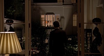 Movie still from “Match Point” (2005), directed by Woody Allen – A man standing in front of an open door; Wide shot, Over the shoulder angle