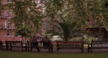 Movie still from “Match Point” (2005), directed by Woody Allen – Two people sitting on park benches under a tree; Extreme Wide shot, High angle