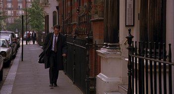 Movie still from “Match Point” (2005), directed by Woody Allen – A man walking down the sidewalk of a city street; Wide shot, Low angle