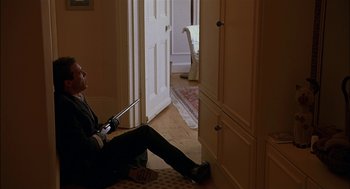 Movie still from “Match Point” (2005), directed by Woody Allen – A man sitting on the ground holding a cell phone; Wide shot, High angle