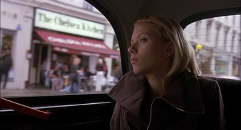Movie still from “Match Point” (2005), directed by Woody Allen – A woman sitting in the back of a car looking out the window; Medium shot, Low angle