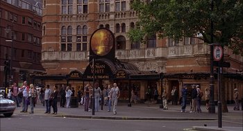 Movie still from “Match Point” (2005), directed by Woody Allen – A group of people walking on the sidewalk near a building; Extreme Wide shot, Low angle