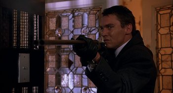 Movie still from “Match Point” (2005), directed by Woody Allen – A man in a black suit holding a wooden stick; Close Up shot, Low angle