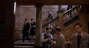 Movie still from “Match Point” (2005), directed by Woody Allen – A group of people standing around a building; Wide shot, High angle