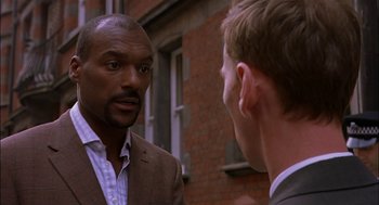 Movie still from “Match Point” (2005), directed by Woody Allen – A man in a suit talking to another man in a suit; Close Up shot, Over the shoulder angle