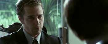 Movie still from “Matchstick Men” (2003), directed by Ridley Scott – A person wearing a suit and tie; Close Up shot, Over the shoulder angle
