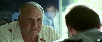 Movie still from “Matchstick Men” (2003), directed by Ridley Scott – An older man looking at himself in the mirror; Close Up shot, Over the shoulder angle