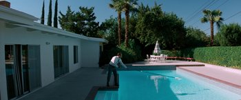 Movie still from “Matchstick Men” (2003), directed by Ridley Scott – A man standing on the edge of a swimming pool; Extreme Wide shot, High angle