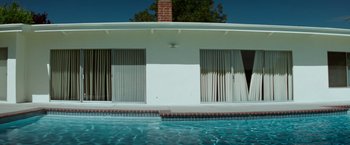 Movie still from “Matchstick Men” (2003), directed by Ridley Scott – A house with a swimming pool in front of it; Extreme Wide shot, Low angle