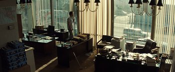 Movie still from “Matchstick Men” (2003), directed by Ridley Scott – A man standing in front of a window in a room; Wide shot, High angle