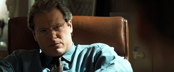 Movie still from “Matchstick Men” (2003), directed by Ridley Scott – A person wearing glasses and a tie; Close Up shot, Over the shoulder angle