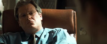 Movie still from “Matchstick Men” (2003), directed by Ridley Scott – A person wearing glasses and a tie; Close Up shot, Low angle
