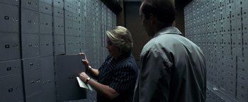 Movie still from “Matchstick Men” (2003), directed by Ridley Scott – A woman and a man are looking at a wall; Medium shot, Low angle