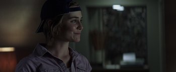 Movie still from “Matchstick Men” (2003), directed by Ridley Scott – A woman wearing a baseball cap looking to her left; Close Up shot, Over the shoulder angle