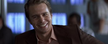 Movie still from “Matchstick Men” (2003), directed by Ridley Scott – A person wearing a suit and smiling; Close Up shot, Over the shoulder angle