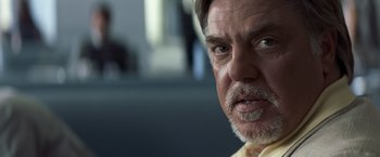 Movie still from “Matchstick Men” (2003), directed by Ridley Scott – An older man with gray hair stares into the camera; Close Up shot, Over the shoulder angle