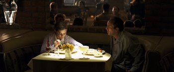 Movie still from “Matchstick Men” (2003), directed by Ridley Scott – A man and a woman sitting at a dinner table; Medium shot, Over the shoulder angle