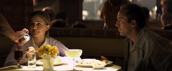 Movie still from “Matchstick Men” (2003), directed by Ridley Scott – A man sitting at a table in front of a plate of food; Medium shot, Over the shoulder angle