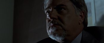 Movie still from “Matchstick Men” (2003), directed by Ridley Scott – An older man with a beard and mustache looking at the camera; Close Up shot, Low angle