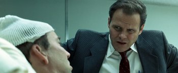 Movie still from “Matchstick Men” (2003), directed by Ridley Scott – A man in a business suit looking into a mirror; Close Up shot, Over the shoulder angle