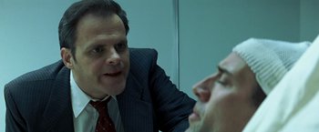 Movie still from “Matchstick Men” (2003), directed by Ridley Scott – A man in a business suit talking to another man in a business suit; Close Up shot, Over the shoulder angle