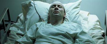 Movie still from “Matchstick Men” (2003), directed by Ridley Scott – A man in a hospital bed wearing a white hat; Close Up shot, Overhead angle