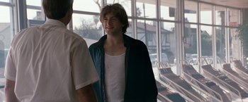 Movie still from “Matchstick Men” (2003), directed by Ridley Scott – A young man standing in front of a window; Medium shot, Over the shoulder angle