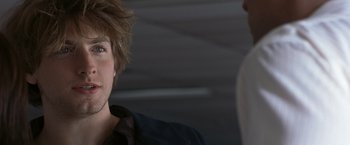 Movie still from “Matchstick Men” (2003), directed by Ridley Scott – A young man with a messy hair style looks at another young man; Close Up shot, Over the shoulder angle