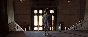 Movie still from “Matilda” (1996), directed by Danny DeVito – A little girl standing in front of an open door; Wide shot, Low angle